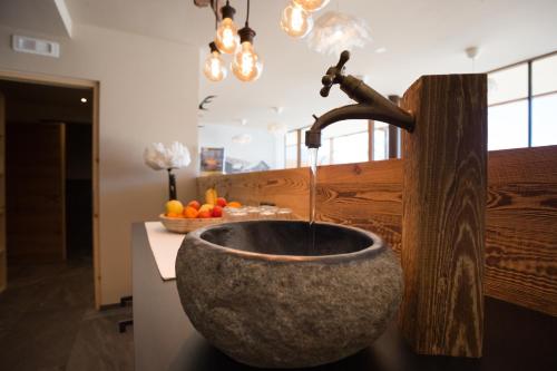a bathroom with a stone sink with a faucet at Leierhof Olivia in Rodengo