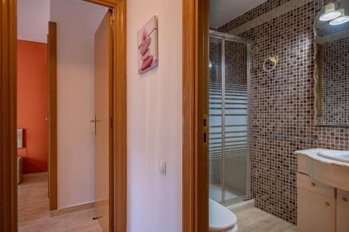 een badkamer met een toilet en een glazen douche bij AT044 Els Porxos in Torredembarra