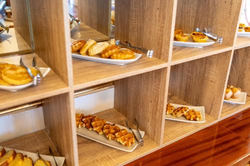 a shelf with plates of pastries and other pastries at Hotel Casabela in Ferragudo