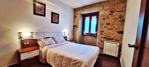 a bedroom with a bed and a brick wall at Casa Monte Toran in Bamiro