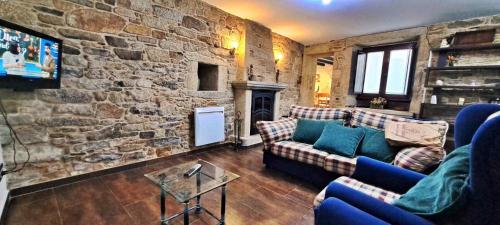 a living room with couches and a stone wall at Casa Monte Toran in Bamiro