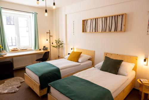 a room with two beds and a desk and a window at Hotel Rehavital in Jablonec nad Nisou