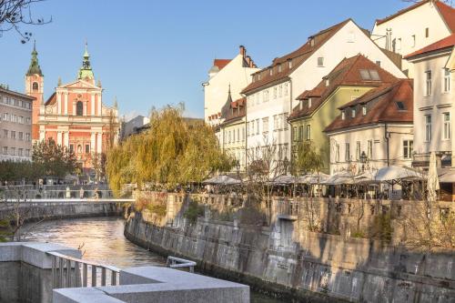 a group of buildings and a river in a city at Central Riverside Apartments Meščanka in Ljubljana