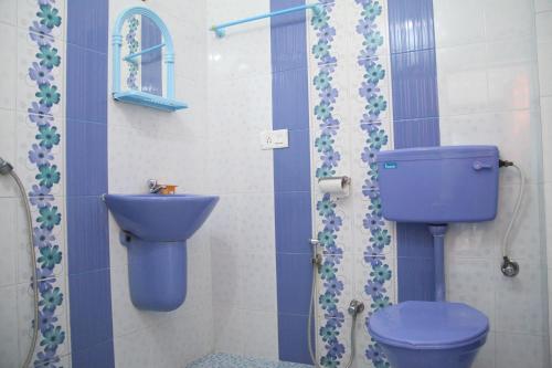 y baño con aseo azul y lavamanos. en DreamCatcher Residency, en Kochi