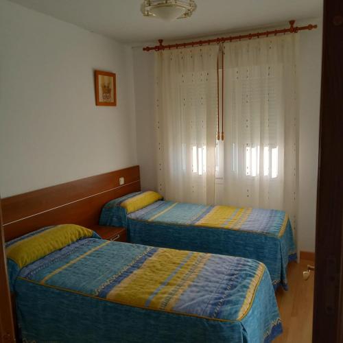 a room with two beds and a window at Río Adaja in El Fresno