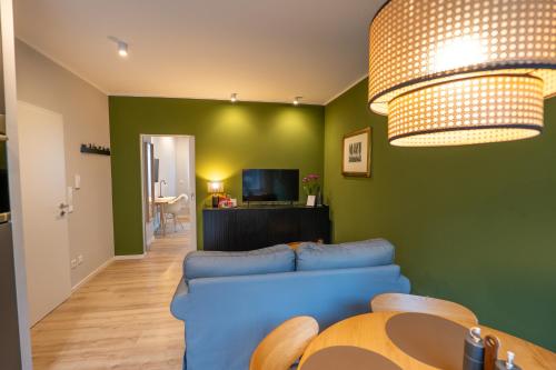帕德博恩的住宿－Im Herzen der Stadt - EG Wohnung，客厅设有蓝色的沙发和绿色的墙壁。