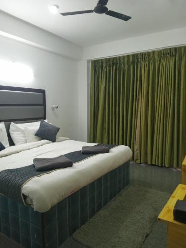 a bedroom with a large bed with a ceiling fan at Hotel Grand View in Chail