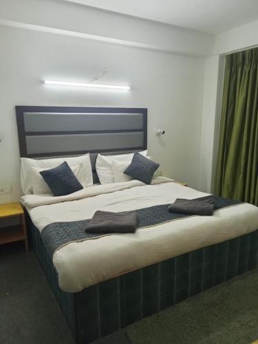 um quarto com uma cama grande e almofadas azuis em Hotel Grand View em Chail