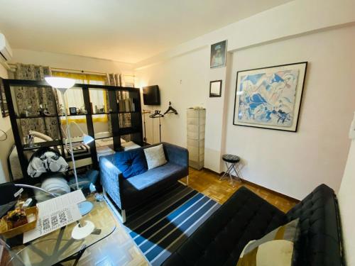 uma sala de estar com um sofá azul e uma mesa em Elegante Loft en Chueca em Madri