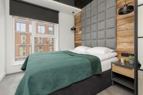 a bedroom with a large bed and two windows at Milionowa Loft Apartment with Parking in Łódź by Noclegi Renters in Łódź