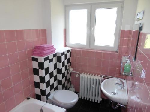 ein rosafarbenes Bad mit einem WC und einem Waschbecken in der Unterkunft Gästehaus HarzGlück in Braunlage