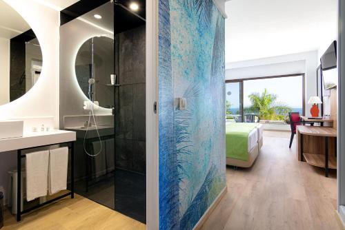 a bathroom with a shower and a bedroom at Hotel Costa Calero Thalasso & Spa in Puerto Calero