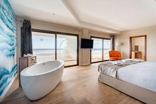 a bedroom with a large bed and a bath tub at Hotel Costa Calero Thalasso & Spa in Puerto Calero