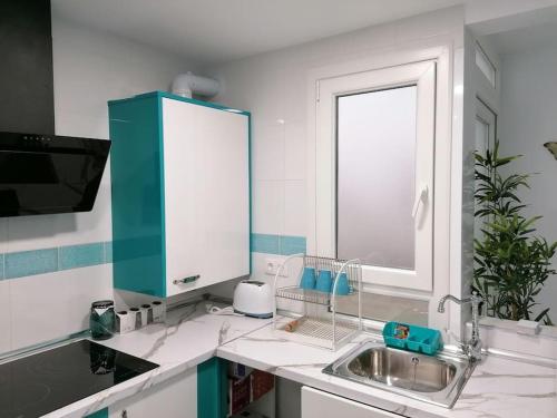 a kitchen with a sink with a mirror and a window at Fantástico Piso Turquesa in Valladolid