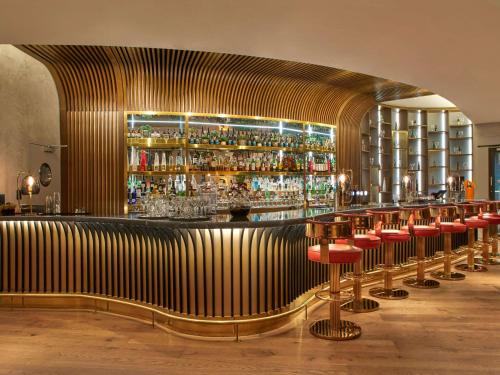 un bar con un mucchio di sgabelli da bar in una stanza di Sofitel Brussels Europe a Bruxelles