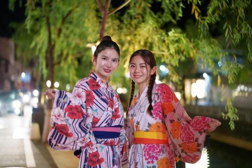 two girls in kimonos standing next to each other at Koyado Enn in Toyooka