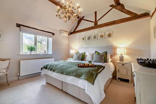 a bedroom with a large bed and a chandelier at Perry Cottage in Halford