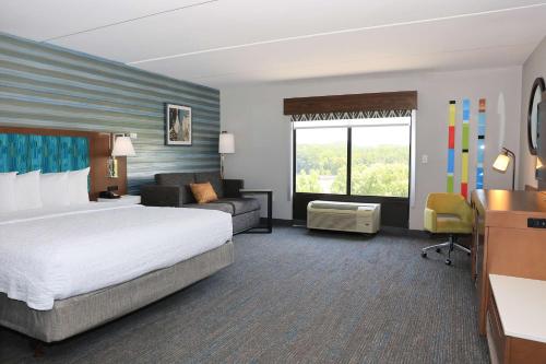a hotel room with a large bed and a couch at Hampton Inn Atlanta-Canton in Canton