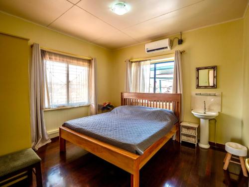 1 dormitorio con 1 cama y lavamanos. en Stunning 3-Bed House in Paramaribo Marie's place, en Paramaribo