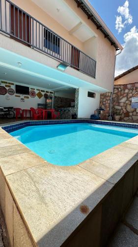 a large swimming pool in front of a building at Pousada Caminho das Cachoeiras Pirenopolis in Pirenópolis