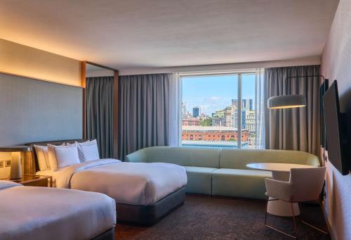 a hotel room with two beds and a couch at Hilton Buenos Aires in Buenos Aires