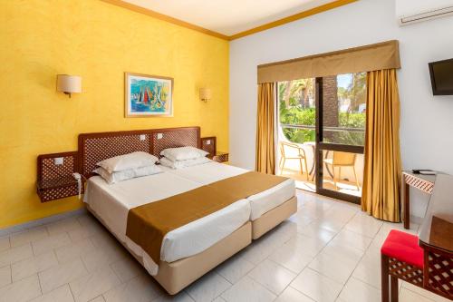 a bedroom with a large bed and a balcony at Hotel Casabela in Ferragudo