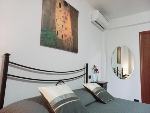 a bedroom with a bed and a painting on the wall at B&B ROSE OSIMO in Osimo