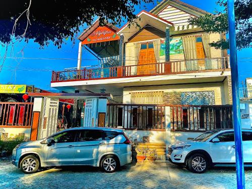 two cars parked in front of a building at Nybipu Homestay in Phan Rang