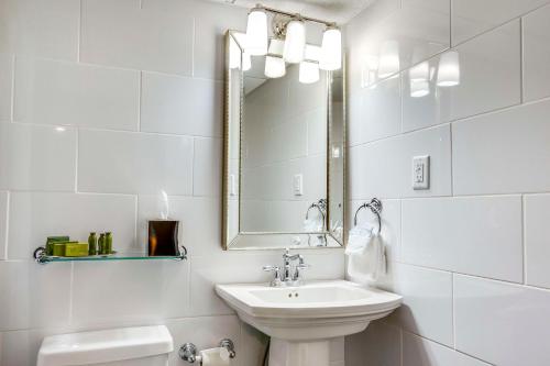 a white bathroom with a sink and a mirror at The Campbell House Lexington, Curio Collection by Hilton in Lexington