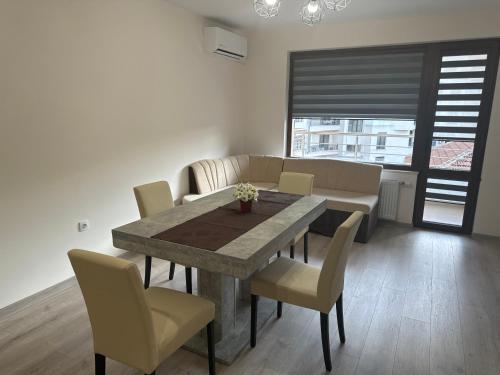 a dining room with a table and chairs and a couch at Хрис in Dobrich