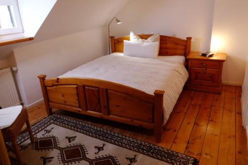 a bedroom with a wooden bed and a wooden floor at Landgasthof Kirschgarten in Ingelheim am Rhein