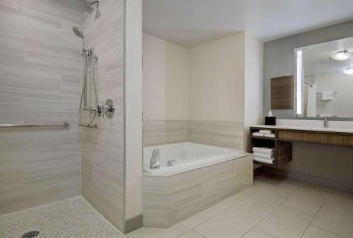 ein Badezimmer mit einer Badewanne und einem Waschbecken in der Unterkunft Hilton Garden Inn at PGA Village/Port St. Lucie in Port Saint Lucie