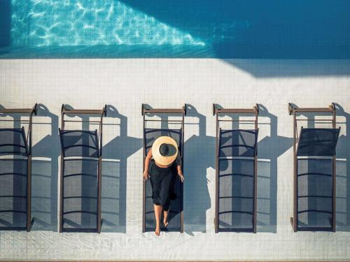 a person in a hat is standing next to someadders at Novotel Rio de Janeiro Leme in Rio de Janeiro