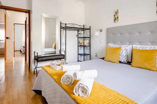 - une chambre avec un grand lit et des serviettes dans l'établissement Jose & Ester House, à Almada