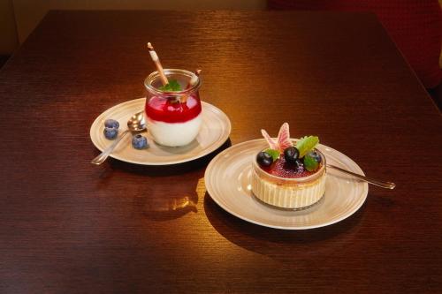 two plates of desserts on a wooden table at H+ Hotel Bochum in Bochum