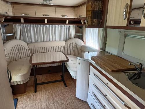 Batomalj的住宿－landhaus-krk，小厨房配有白色的椅子和桌子