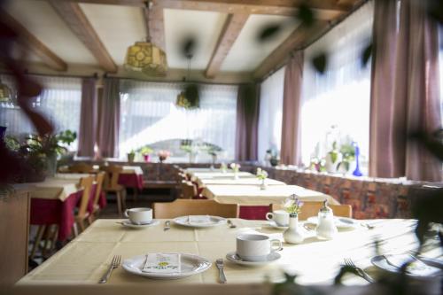 un comedor con mesas, sillas y ventanas en Sonnenberg, en Silandro