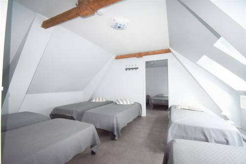 Duas camas num quarto com paredes brancas em La Maison de Julise em Cossé-le-Vivien