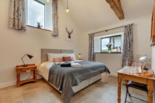 a bedroom with a bed and two windows at Fox in Charlbury