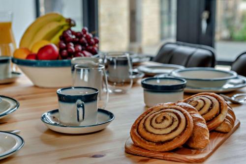 a wooden table with pastries and a bowl of fruit at Fox in Charlbury