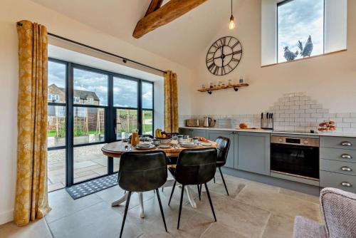 a kitchen with a table and chairs and a large window at Fox in Charlbury