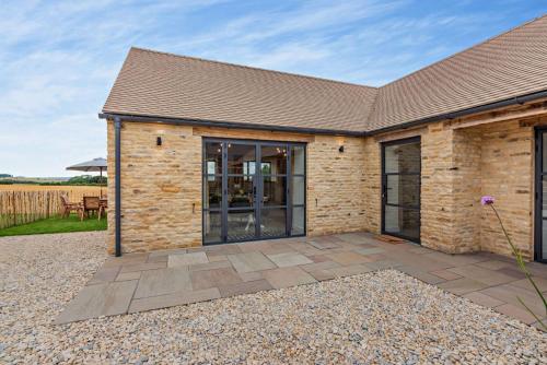 a brick house with a patio in front of it at Fox in Charlbury