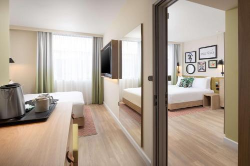 a hotel room with a bedroom with a bed and a mirror at Hampton By Hilton London Old Street in London