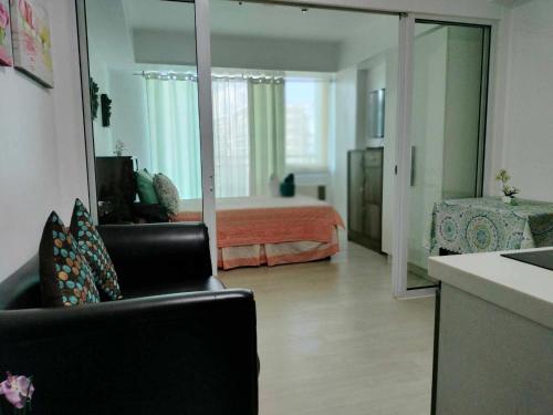 um quarto com uma cama, uma cadeira e um espelho em Oasis at Azure Urban Resorts em Manila