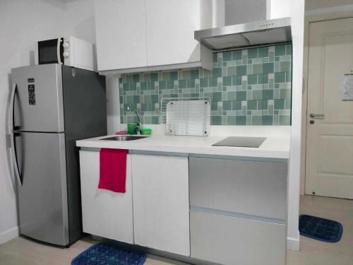 uma cozinha com um frigorífico e um lavatório em Oasis at Azure Urban Resorts em Manila