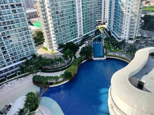 an aerial view of a pool in a city with tall buildings at Oasis at Azure Urban Resorts in Manila