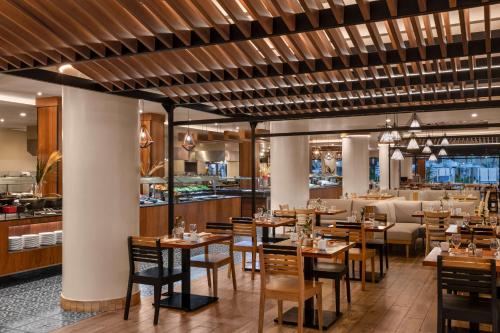 un restaurante con mesas y sillas de madera y un bar en Hilton Cancun Mar Caribe All-Inclusive Resort, en Cancún