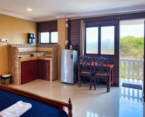 a kitchen with a refrigerator and a table with a dining room at Pele's Fisherman Beach Stay in Benaulim