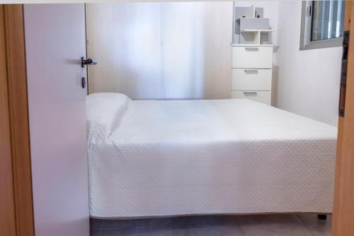 a small room with a white bed and a closet at SE040 - Senigallia, bilocale fronte mare con giardino in Scapezzano