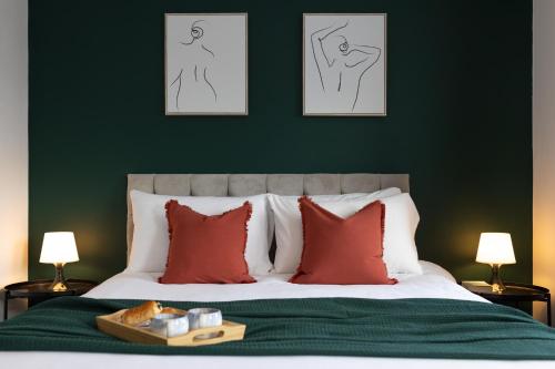 a green bedroom with a bed with red pillows at Modern 2-Bed Townhouse in Kirkdale in Liverpool